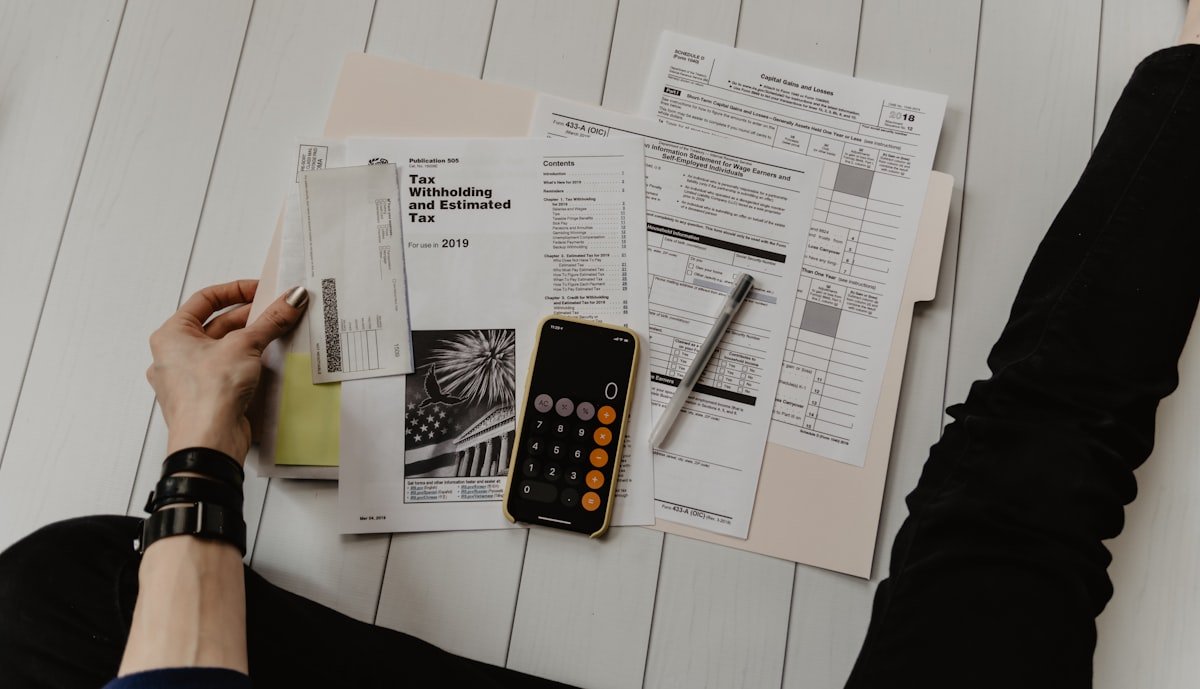 Tax documents, receipts, and a calculator spread across a desk